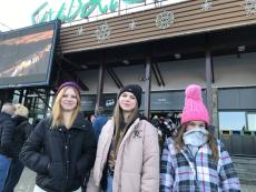 Trzy uśmiechnięte dziewczynki pozują do zdjęcia na tle budynku kas biletowych na kolejkę linową na gubałówkę